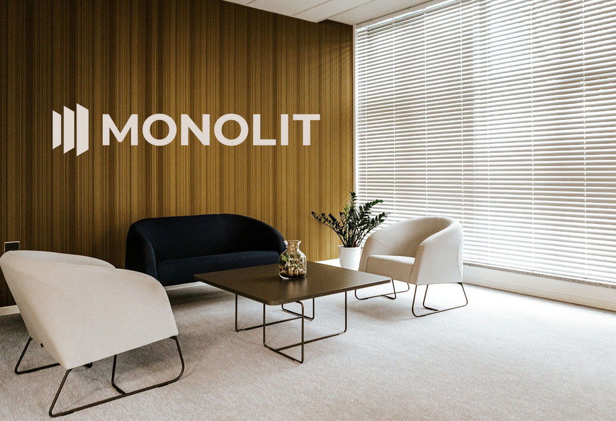 Zdjęcie w pionie przedstawiające wnętrze salonu z roletami wewnętrznymi oraz logo Monolit.