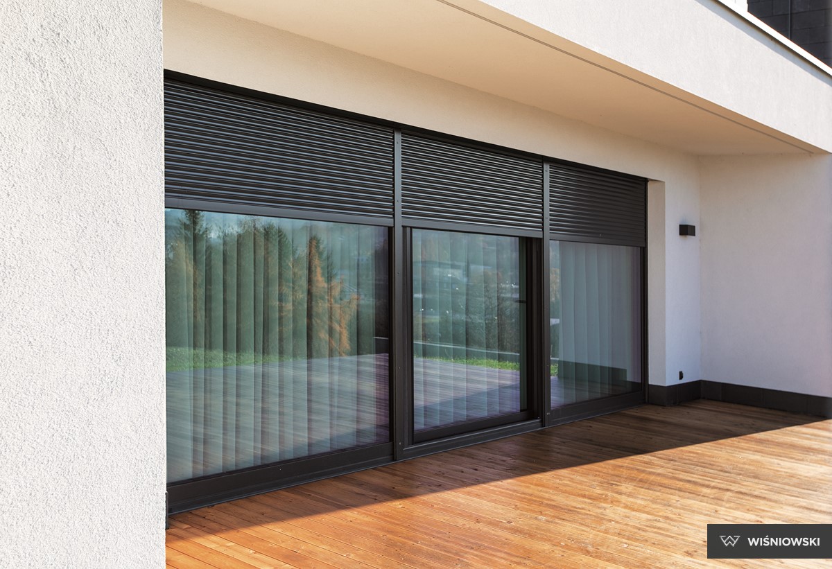 zdjęcie przedstawiające panoramiczne okna i drzwi tarasowe oraz rolety zewnętrzne protecta, których producentem jest firma wiśniowski